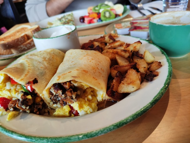 Freshly made breakfast wrap with vibrant greens and a side of crispy hash browns.