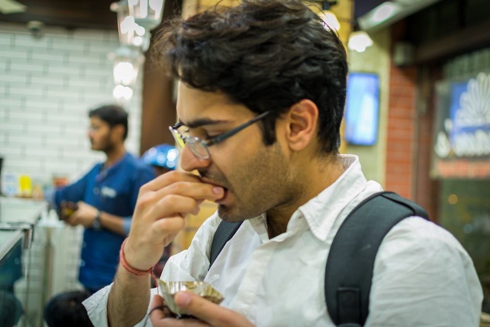 a man eating food in a restaurant while another man watches