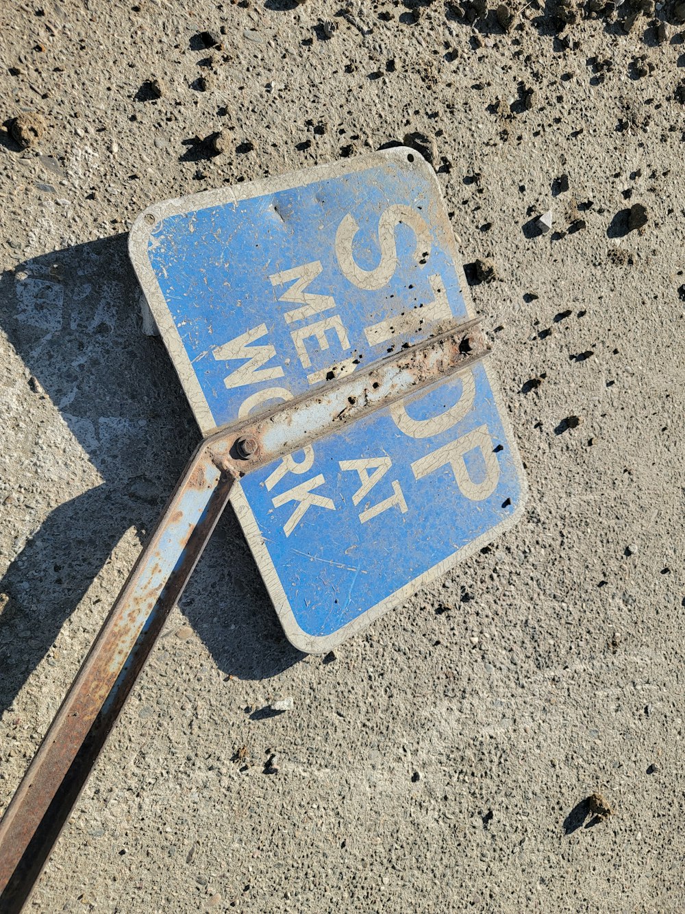 a blue street sign laying on the ground