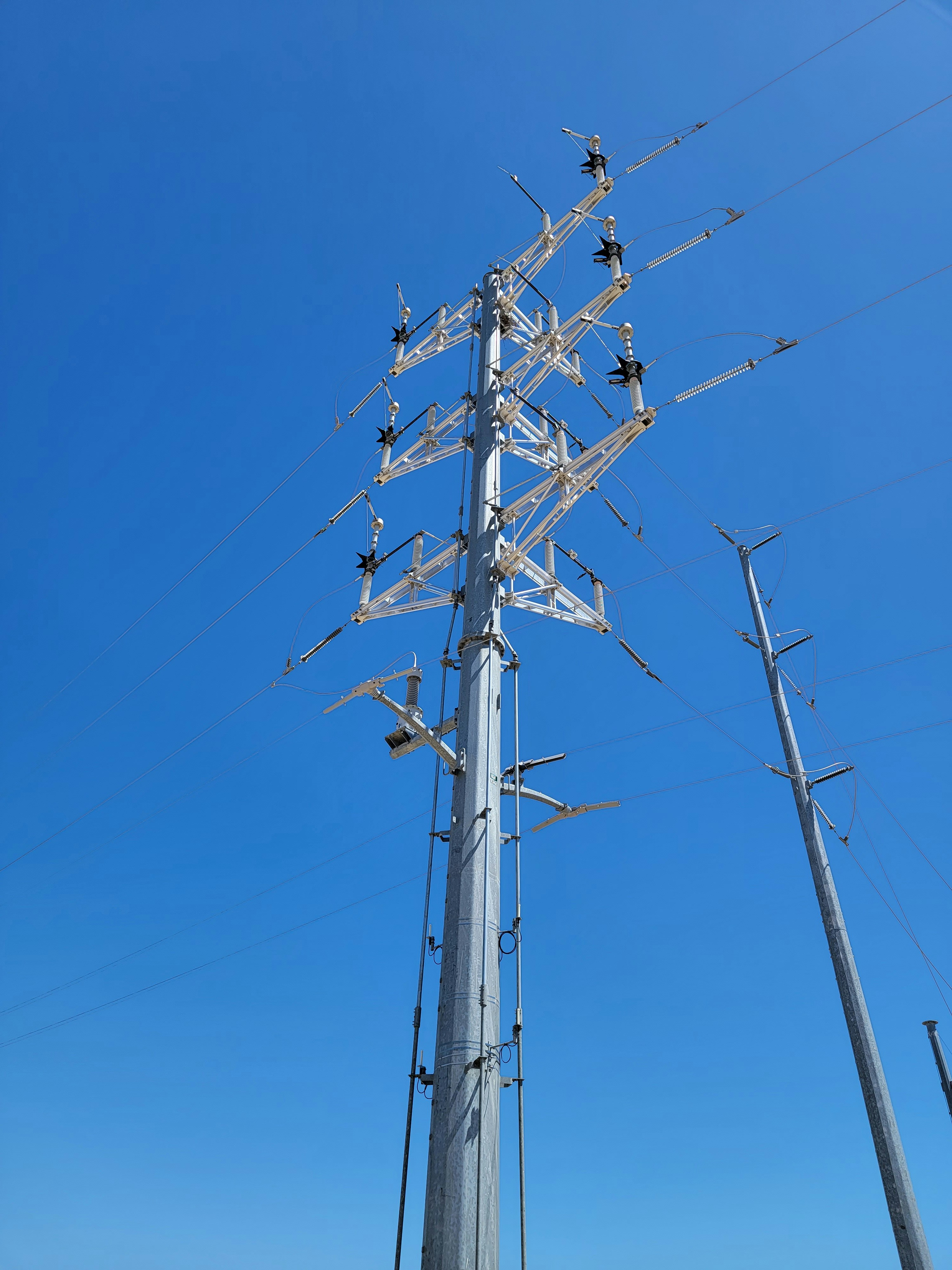 a tall metal pole with lots of wires on top of it