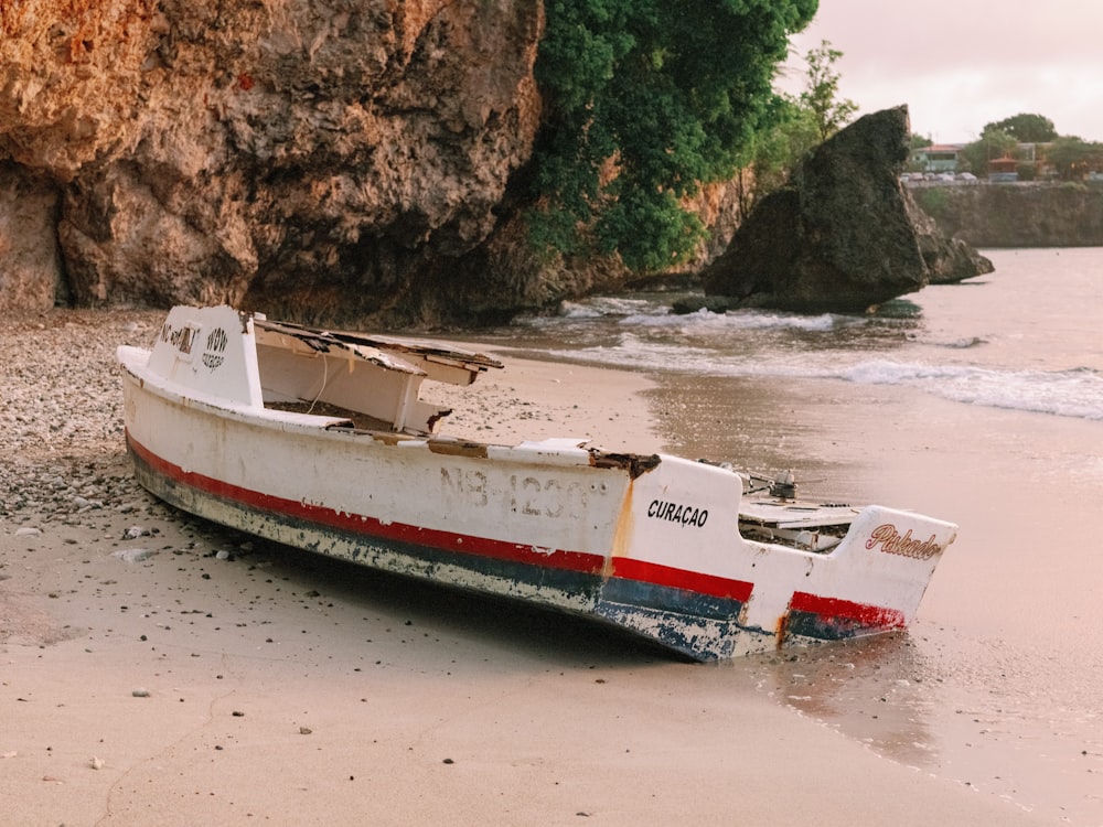 ein kleines Boot, das auf einem Sandstrand sitzt