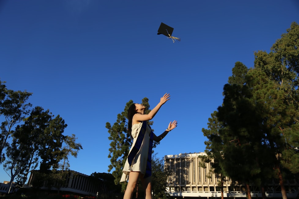 A joyful graduation ceremony with students throwing caps in the air.