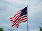 a large american flag flying in the wind