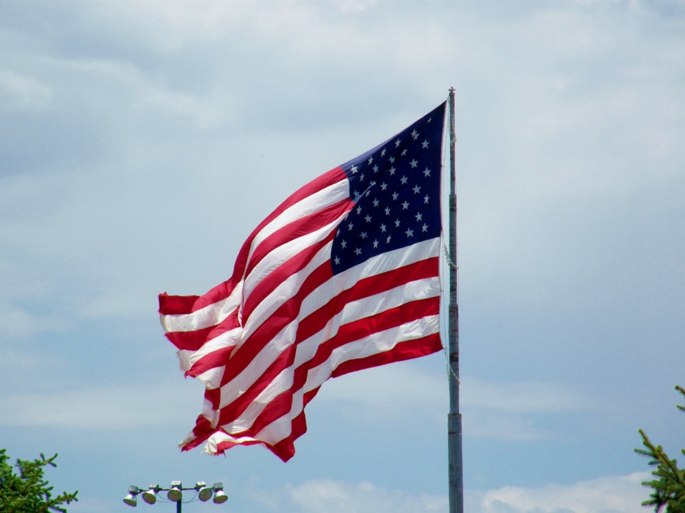 a large american flag flying in the wind