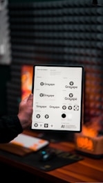 a person holding up a tablet with a bunch of buttons on it