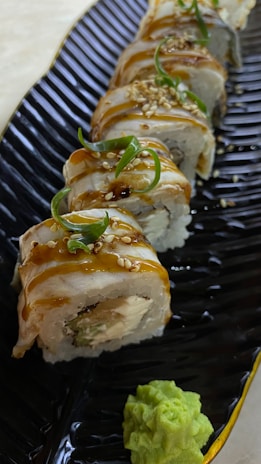 A vibrant platter of sushi rolls artfully arranged with colorful garnishes and wasabi.