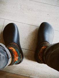 Close-up of colorful punk-style socks with bold patterns on a wooden floor.