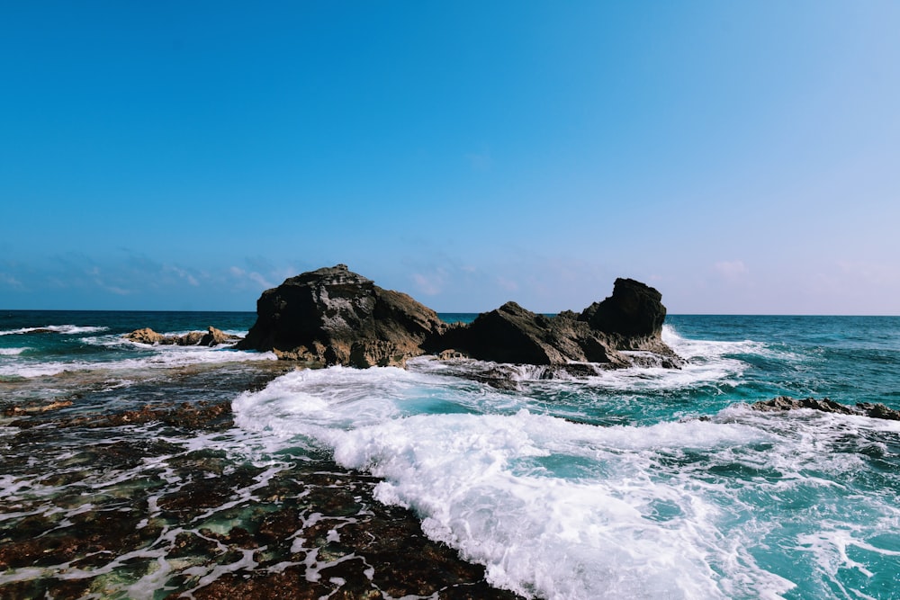 a rock formation in the middle of a body of water