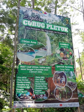 A promotional signboard for Curug Pletuk located in a lush, green area. The sign includes various offerings such as a camping package for the new year, starting December 2, 2023, to January 2, 2024. It features images of natural attractions, such as a waterfall and a pool, as well as local culinary highlights. The board details package prices and amenities like free parking and durian. Contact information and social media handles are visible at the bottom.