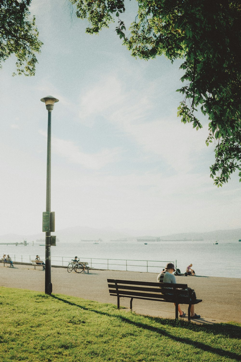 a man sitting on a park bench next to the ocean