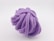 A coiled purple rope with a detailed texture, resting against a plain white background. The rope appears to be thick and tightly wound, showcasing its intricate woven pattern.
