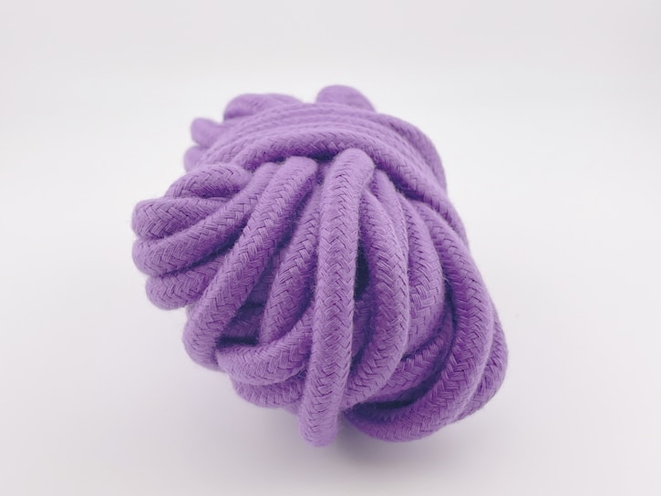 a purple ball of rope on a white background