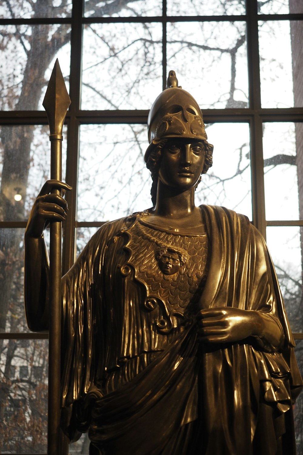 Una estatua de un soldado romano frente a una ventana