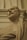 A classical-style marble bust of a bearded man, draped in a toga, set against an ornate architectural background. The sculpture exhibits fine detailing and a lifelike expression, capturing the essence of historical art.