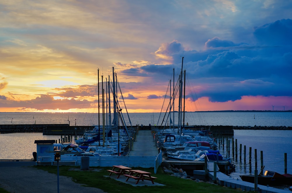 a dock with many boats docked at sunset