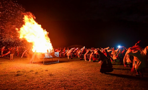 Community members gathered around a bonfire during a festive night.