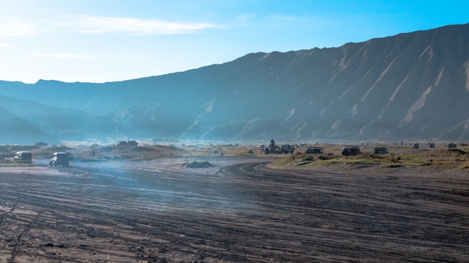 A scenic view of Valle de Bravo's mountains with an off-road vehicle trail winding through the forest.