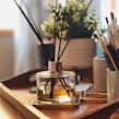 An elegant diffuser with amber tones placed on a wooden table surrounded by cozy home decor.
