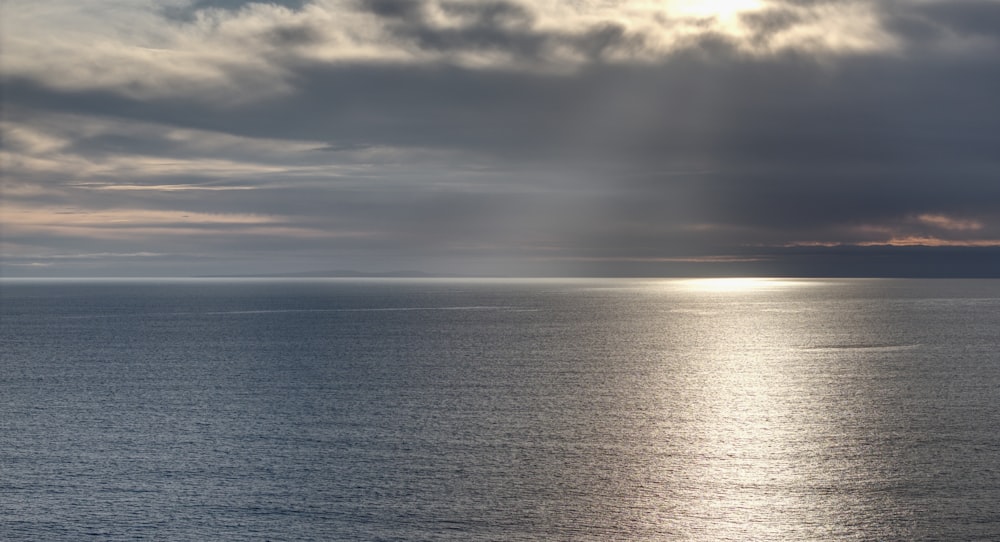 a large body of water under a cloudy sky