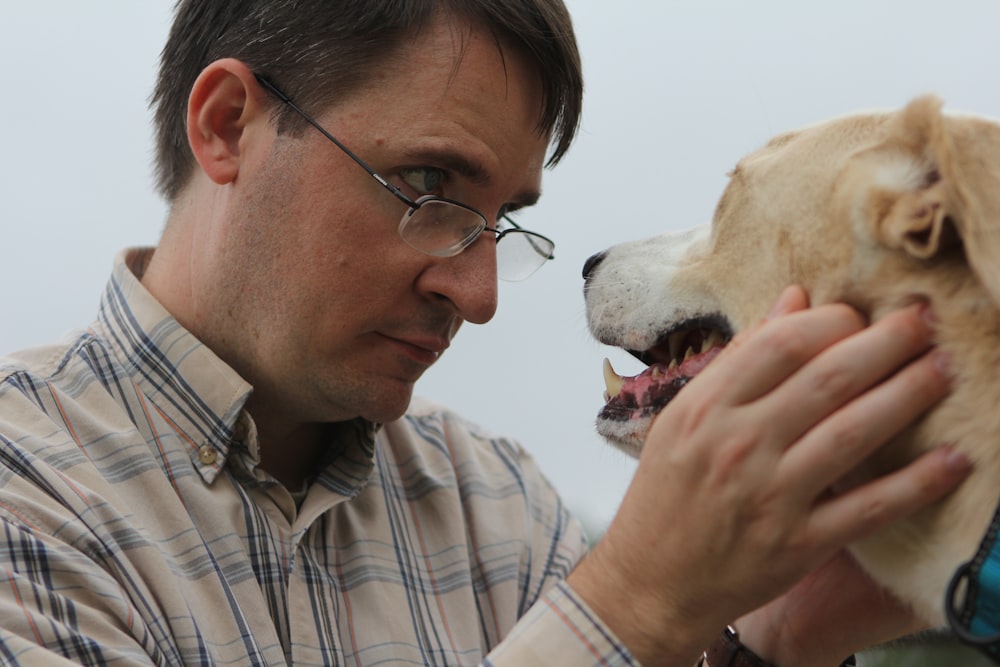 a man petting a dog with his mouth open