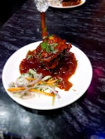 A vibrant plate of şırdan served with fresh herbs and lemon wedges.