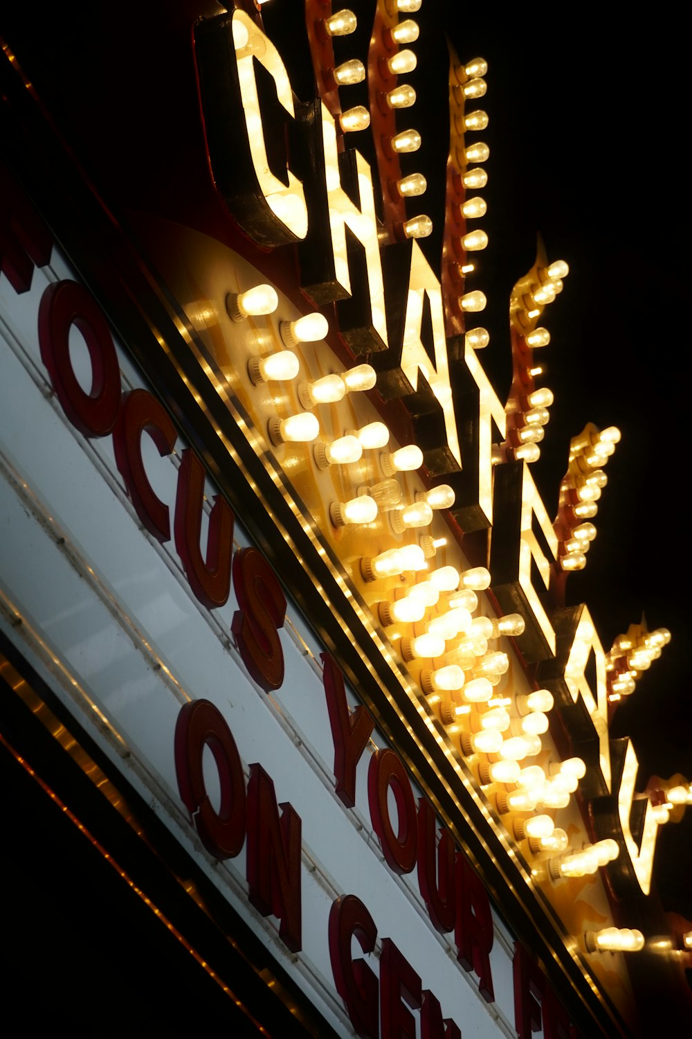 a theater sign lit up at night with lights