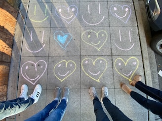 A vibrant street filled with chalk art and smiling passersby.