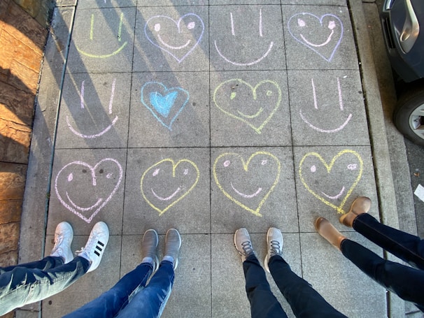 A vibrant street filled with chalk art and smiling passersby.