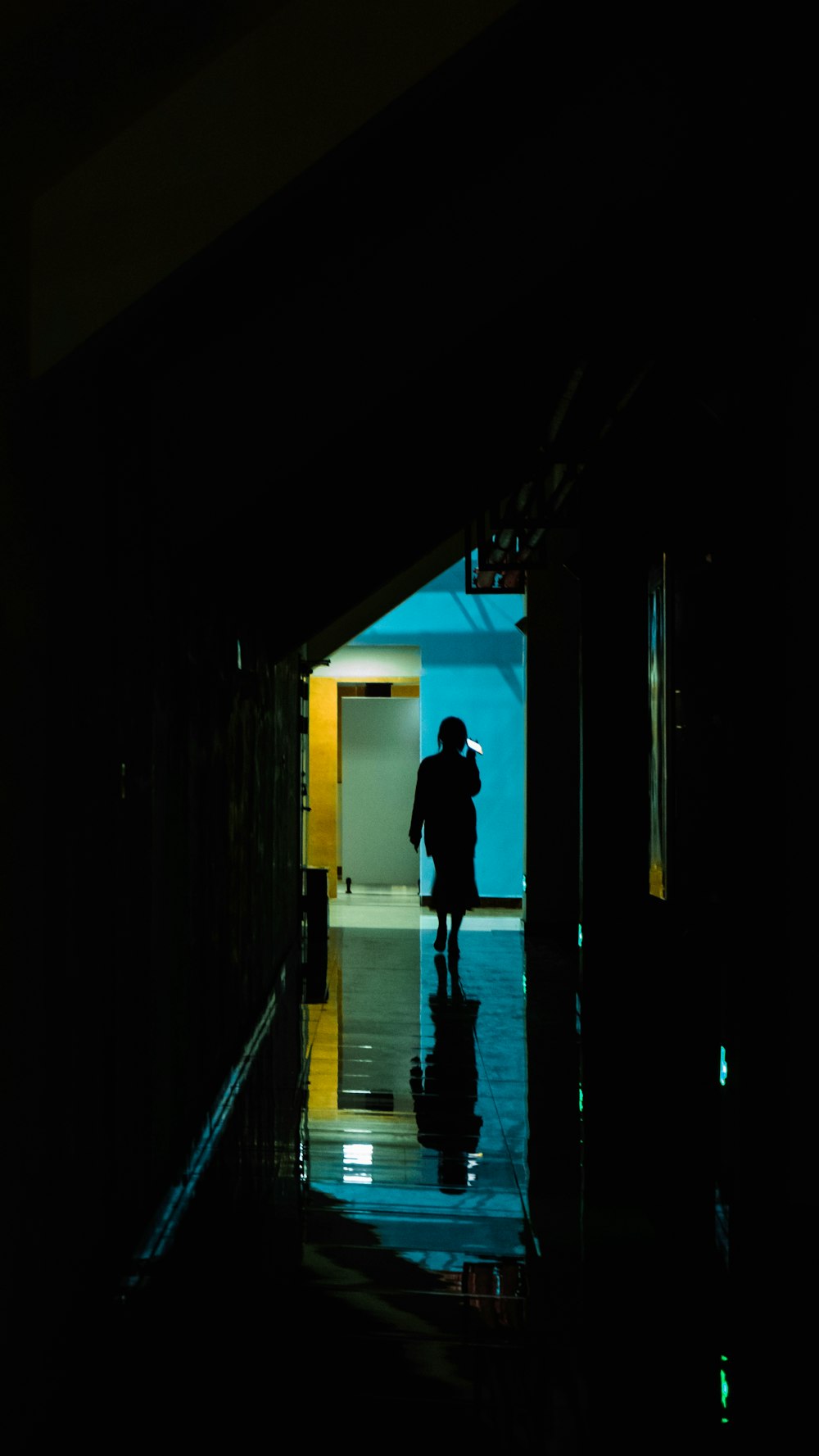 a person walking down a hallway in the dark