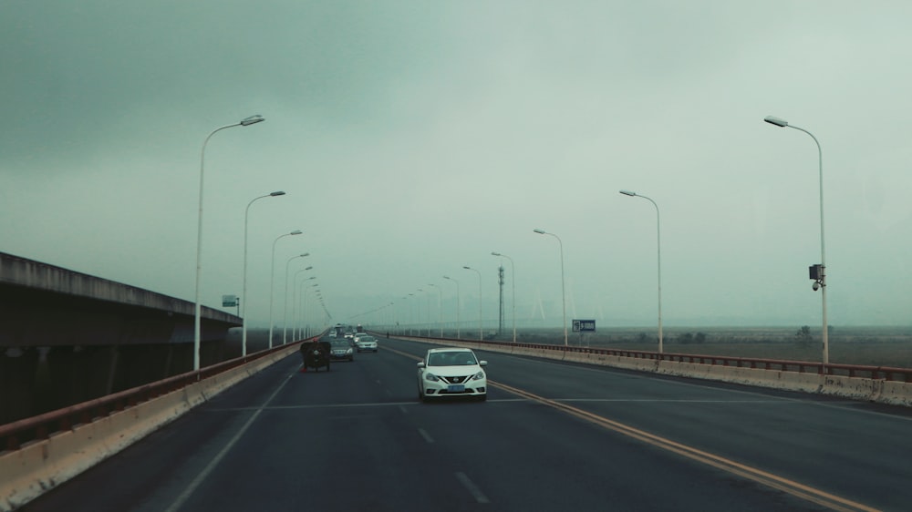 a car driving down a highway under a cloudy sky