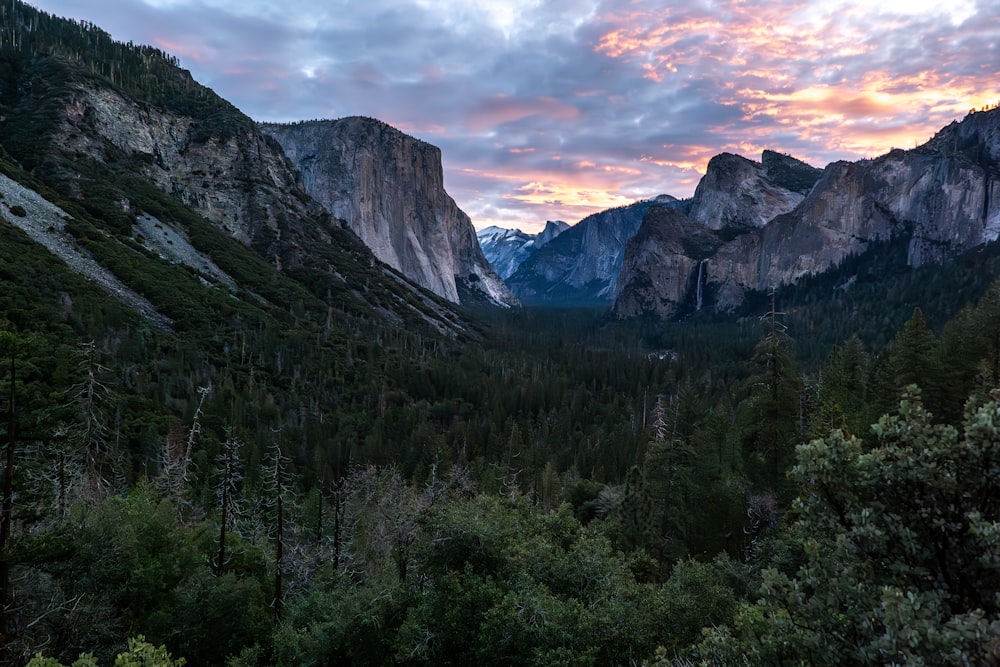 the sun is setting over the mountains in the valley