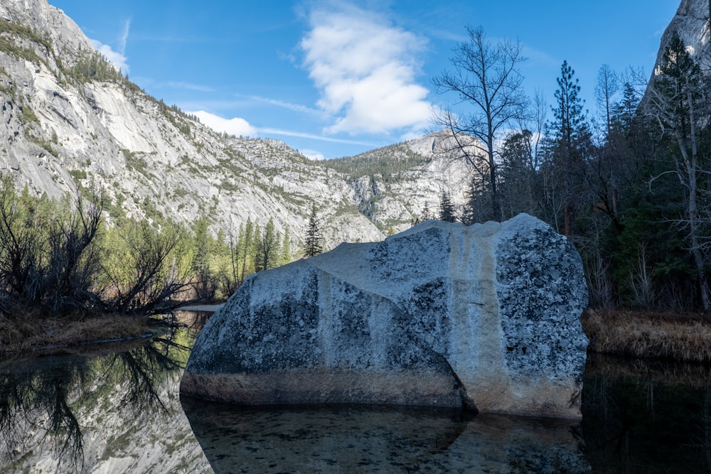 a large rock sitting in the middle of a lake