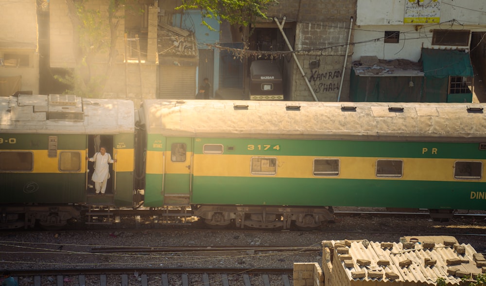 a green and yellow train traveling down train tracks