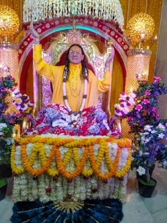 A regal Maharaja in traditional attire seated on an ornate throne, bathed in warm golden light.