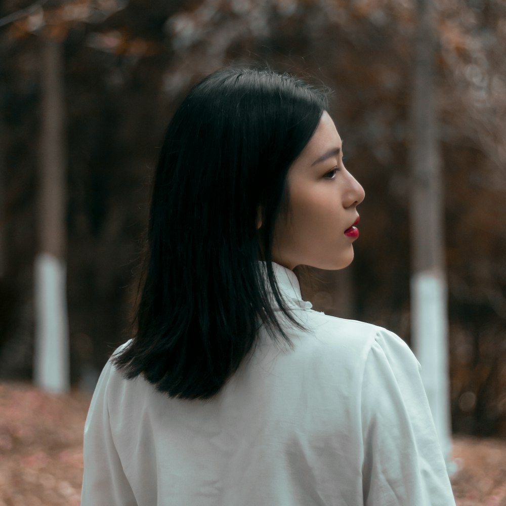 a woman with long black hair and a white shirt