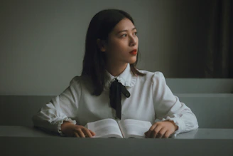 A calm woman working peacefully at her desk with soft natural light.