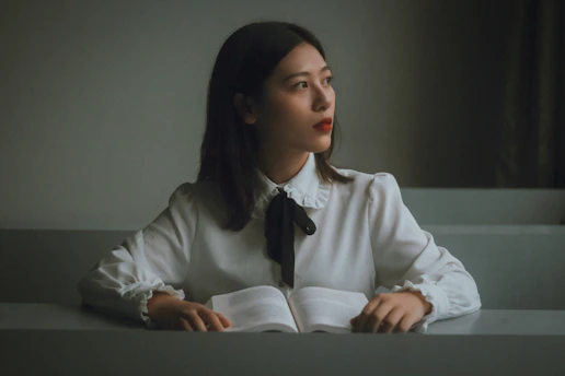 A candid portrait of Sarah Edwards working thoughtfully at her desk surrounded by books and notes.