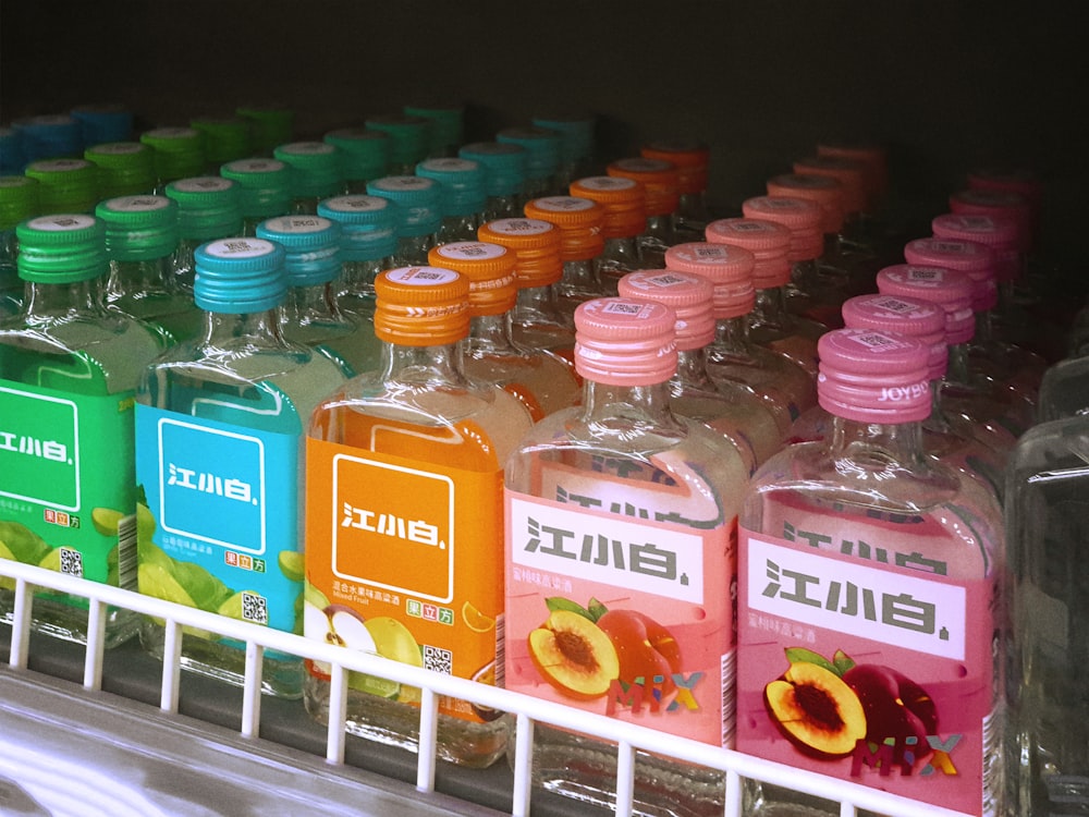 a shelf filled with bottles of different kinds of drinks