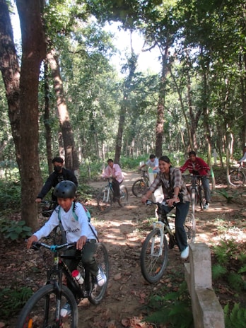 A group of diverse people happily cycling together on a sunny trail.