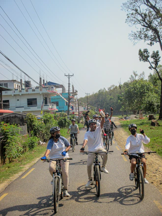 A lively group of friends laughing and pedaling together on a beer bike through a sunny town street.