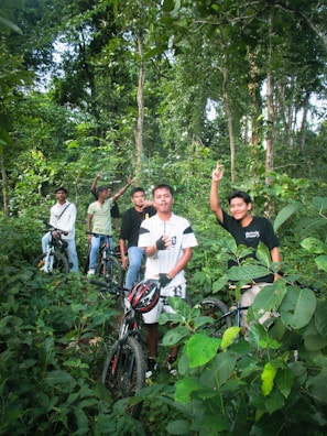 A group of adventure riders setting up camp in a lush forest.