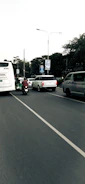 A fleet of buses equipped with AIS-140 certified tracking devices on a busy city road.