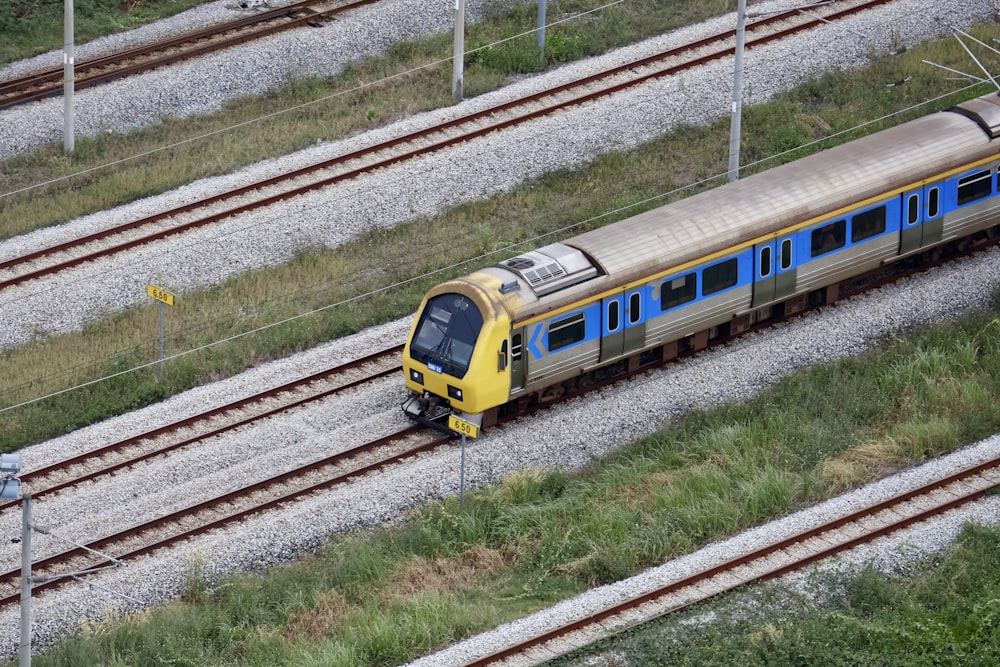 a yellow and blue train traveling down train tracks