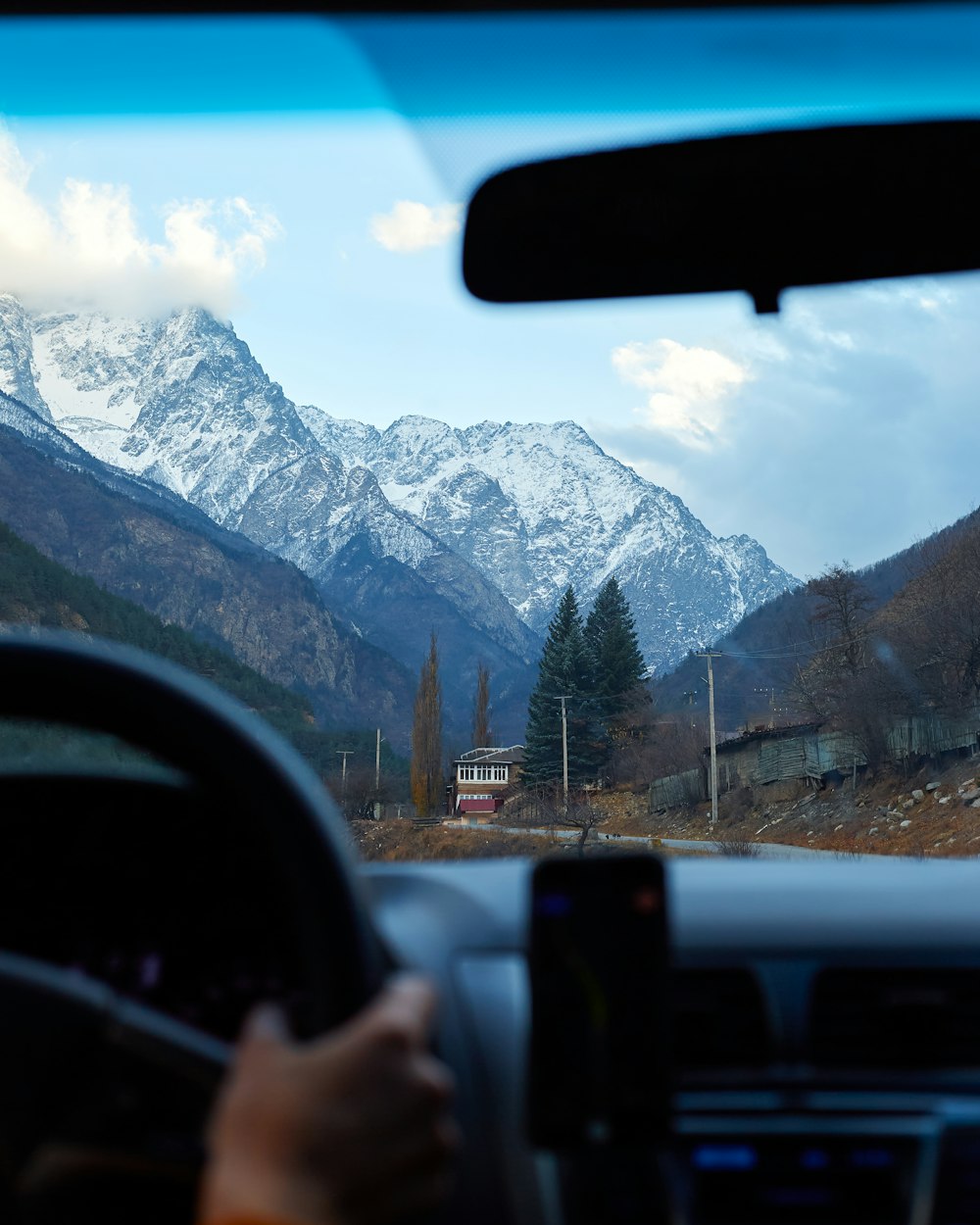a person driving a car in front of a mountain range