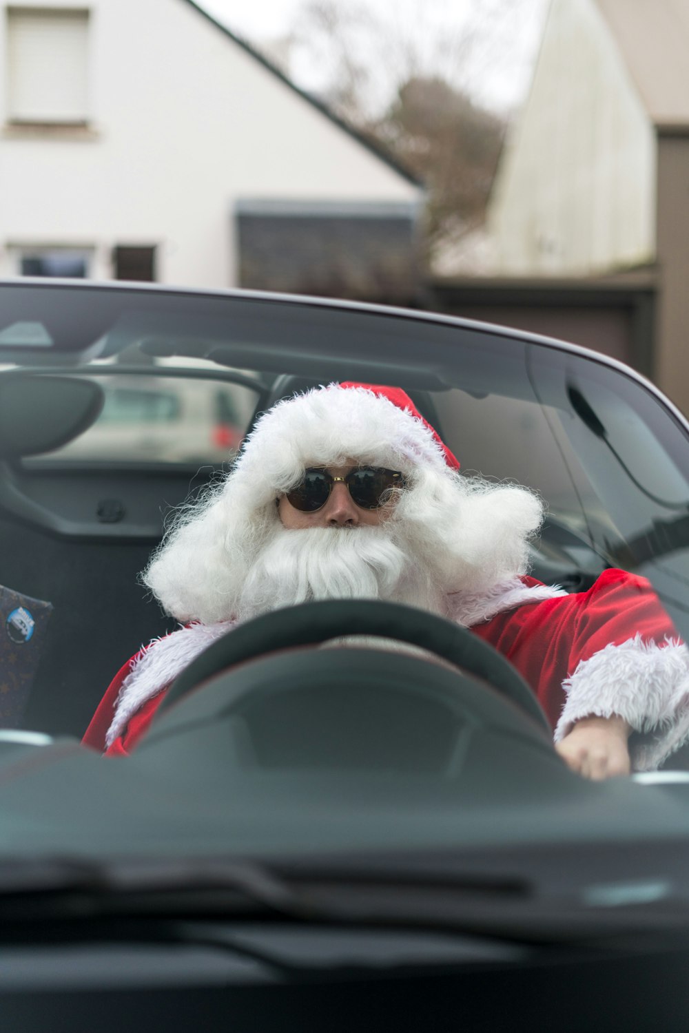 a man dressed as santa claus driving a car