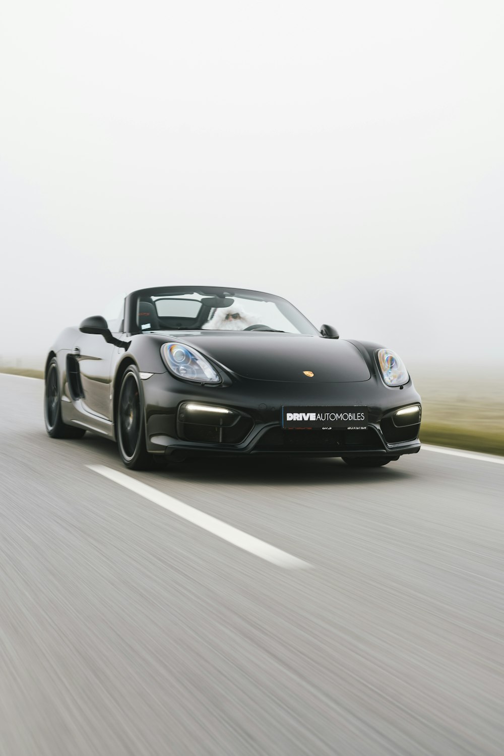 a black sports car driving down a road