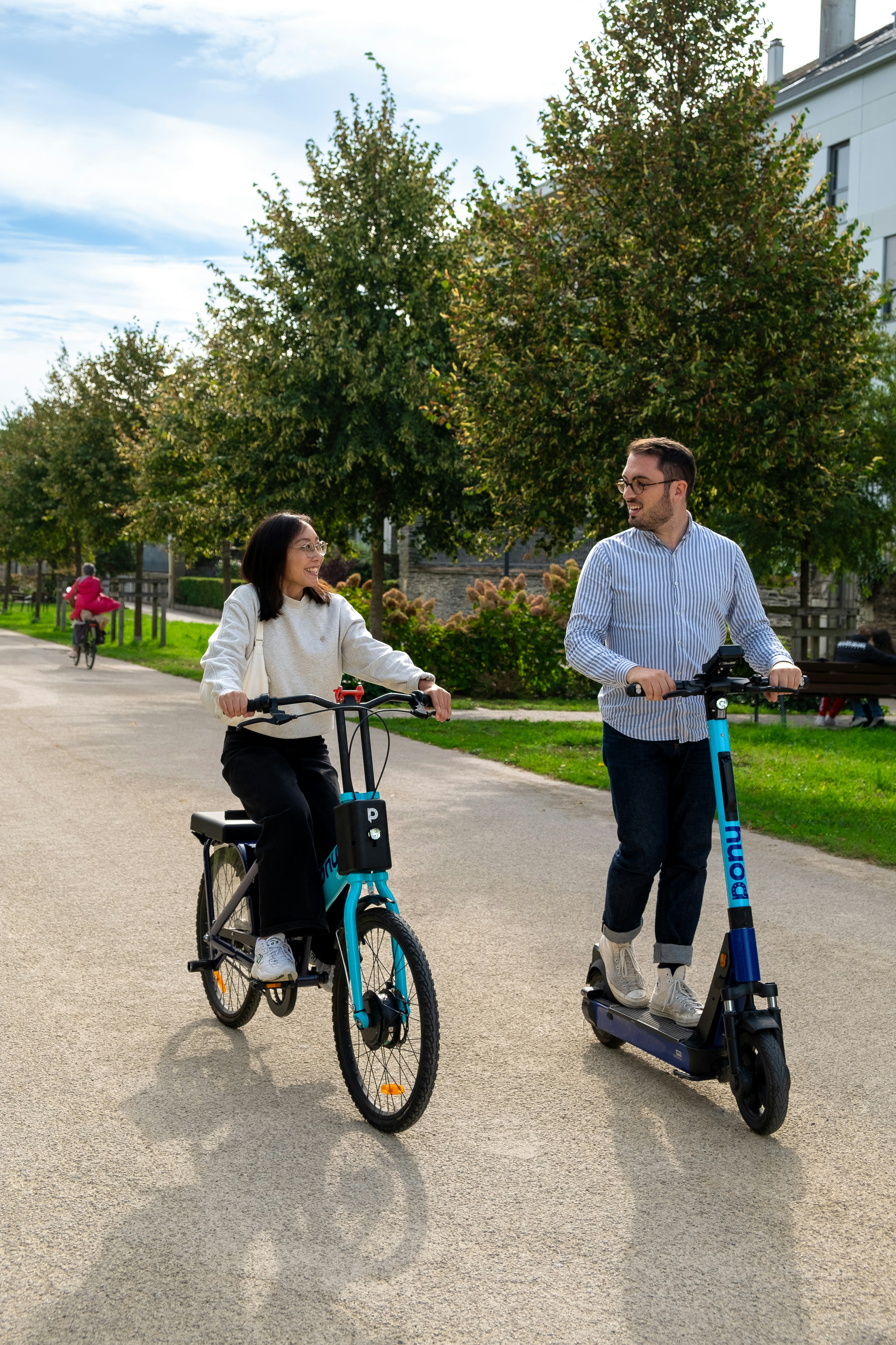 a man and a woman riding on a scooter