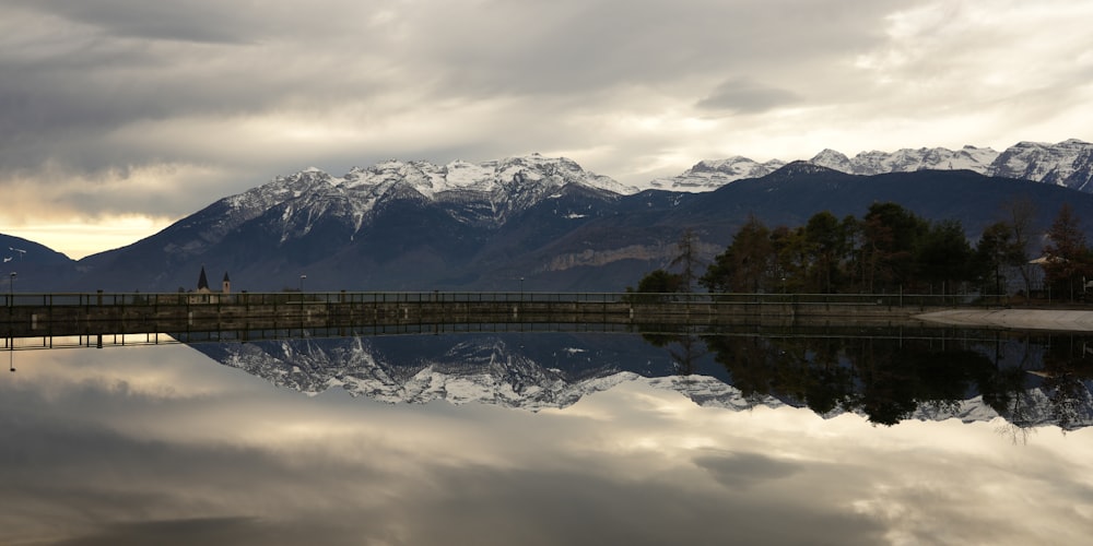 Un plan d’eau entouré de montagnes sous un ciel nuageux