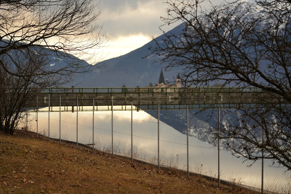 un ponte su uno specchio d'acqua con una montagna sullo sfondo