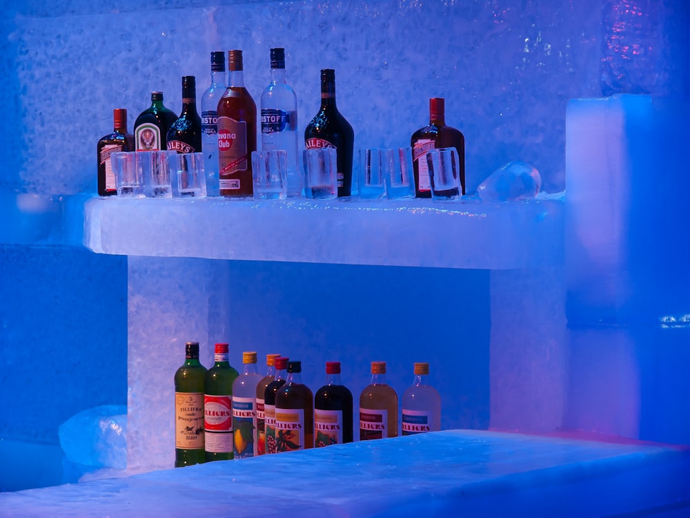 bottles of alcohol are lined up on a shelf